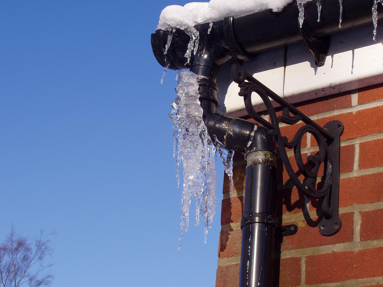 frozen pipe along an exterior brick wall